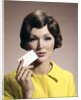 1960s Brunette Woman Holding Blank Business Card To Face Looking At Camera Wearing Yellow Top by Anonymous