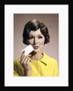 1960s Brunette Woman Holding Blank Business Card To Face Looking At Camera Wearing Yellow Top by Anonymous