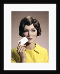 1960s Brunette Woman Holding Blank Business Card To Face Looking At Camera Wearing Yellow Top by Anonymous