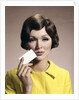 1960s Brunette Woman Holding Blank Business Card To Face Looking At Camera Wearing Yellow Top by Anonymous