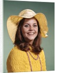 1970s Smiling Young Woman Wearing Yellow Floppy Brim Hat And Blouse With Pink Beads Looking At Camera by Anonymous