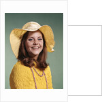 1970s Smiling Young Woman Wearing Yellow Floppy Brim Hat And Blouse With Pink Beads Looking At Camera by Anonymous