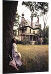 1960s 1970s Woman Standing Beside Tree Front Of Abandoned Haunted Victorian House by Anonymous
