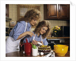 1970s Mother Daughter Dressed Alike Decorating Cake by Anonymous