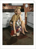 1960s Tired Housewife Sitting On Top Of Laundry Basket In Kitchen by Anonymous