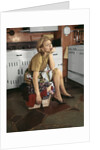 1960s Tired Housewife Sitting On Top Of Laundry Basket In Kitchen by Anonymous