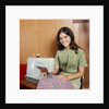 1970s Young Woman Teenager Using A Singer Sewing Machine Looking At Camera by Anonymous