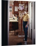 1970s Teenage Boy Talking On Kitchen Wall Phone Telephone by Anonymous