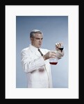 1960s Man Wearing Lab Coat Pouring Liquid From Small Erlenmeyer Flask Into A Larger Flask by Anonymous