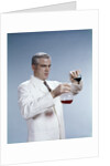 1960s Man Wearing Lab Coat Pouring Liquid From Small Erlenmeyer Flask Into A Larger Flask by Anonymous