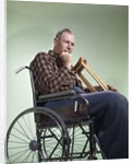 1960 1960s Retro Senior Man Sitting In Wheelchair With Crutches Blanket Wrapped Around Legs by Anonymous