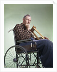 1960 1960s Retro Senior Man Sitting In Wheelchair With Crutches Blanket Wrapped Around Legs by Anonymous