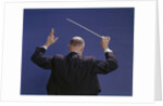 1950s 1960s 1970s View Of Back Of Bald Man Conducting A Symphony Orchestra by Anonymous