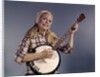 1960s Young Blonde Woman Wearing Plaid Shirt Playing Banjo Singing Folk Music Looking At Camera by Anonymous