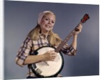 1960s Young Blonde Woman Wearing Plaid Shirt Playing Banjo Singing Folk Music Looking At Camera by Anonymous