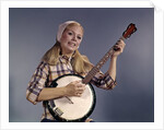 1960s Young Blonde Woman Wearing Plaid Shirt Playing Banjo Singing Folk Music Looking At Camera by Anonymous
