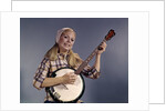 1960s Young Blonde Woman Wearing Plaid Shirt Playing Banjo Singing Folk Music Looking At Camera by Anonymous