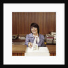 1970s Smiling Woman Bank Teller Handing Cash Over Counter by Anonymous