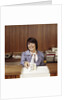 1970s Smiling Woman Bank Teller Handing Cash Over Counter by Anonymous