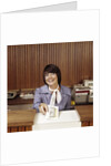 1970s Smiling Woman Bank Teller Handing Cash Over Counter by Anonymous