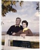 portrait Couple Husband & Wife Smiling Standing Together Behind White Board Fence Outdoor by Anonymous