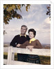 portrait Couple Husband & Wife Smiling Standing Together Behind White Board Fence Outdoor by Anonymous