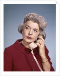 1960s Senior Middle Aged Woman Red Blouse Serious Expression Talking On Telephone by Anonymous
