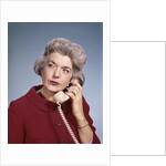 1960s Senior Middle Aged Woman Red Blouse Serious Expression Talking On Telephone by Anonymous