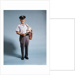 1970s Standing Full Length Portrait Of Middle Aged Mailman Carrying Mail Bag Wearing Uniform by Anonymous
