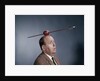 1960s Anxious Nervous Man Looking Up At Arrow Shot Through An Apple Sitting On Top Of His Head by Anonymous