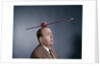 1960s Anxious Nervous Man Looking Up At Arrow Shot Through An Apple Sitting On Top Of His Head by Anonymous
