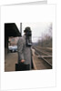 1950s Man Wearing Gas Mask Hat At Commuter Train Station Holding Briefcase Newspaper by Anonymous