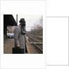 1950s Man Wearing Gas Mask Hat At Commuter Train Station Holding Briefcase Newspaper by Anonymous