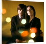 1960s 1970s Young Couple Man Woman Head To Head Dressed In Black Look At Camera Mod Style Serious Expression Blur Lights by Anonymous