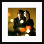 1960s 1970s Young Couple Man Woman Head To Head Dressed In Black Look At Camera Mod Style Serious Expression Blur Lights by Anonymous