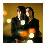 1960s 1970s Young Couple Man Woman Head To Head Dressed In Black Look At Camera Mod Style Serious Expression Blur Lights by Anonymous