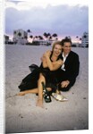 1990s Laughing Couple Man Woman In Formal Wear Sitting Hugging On Beach by Anonymous