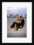 1990s Laughing Couple Man Woman In Formal Wear Sitting Hugging On Beach by Anonymous
