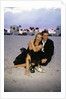 1990s Laughing Couple Man Woman In Formal Wear Sitting Hugging On Beach by Anonymous