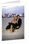 1990s Laughing Couple Man Woman In Formal Wear Sitting Hugging On Beach by Anonymous