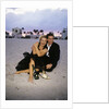 1990s Laughing Couple Man Woman In Formal Wear Sitting Hugging On Beach by Anonymous