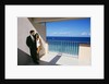 1990s Man In Dark Suit And Tie And Woman In White One Piece Bathing Suit Standing Together On Ocean Side Sun Deck by Anonymous