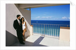 1990s Man In Dark Suit And Tie And Woman In White One Piece Bathing Suit Standing Together On Ocean Side Sun Deck by Anonymous