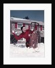 1950s Woman Hiding Behind Sled Throwing Snowball Front Stone House by Anonymous