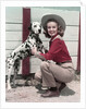 1940s 1950s Smiling Woman Wearing Western Cowgirl Outfit Kneeling Petting Dalmatian Dog by Anonymous