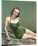 1940s Portrait Smiling Woman Wearing Green Velvet Bathing Suit Sitting Posing On Diving Board by Anonymous