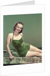 1940s Portrait Smiling Woman Wearing Green Velvet Bathing Suit Sitting Posing On Diving Board by Anonymous
