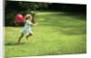 1980s Little Girl With A Red Balloon Running In The Grass by Anonymous
