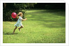 1980s Little Girl With A Red Balloon Running In The Grass by Anonymous