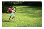 1980s Little Girl With A Red Balloon Running In The Grass by Anonymous